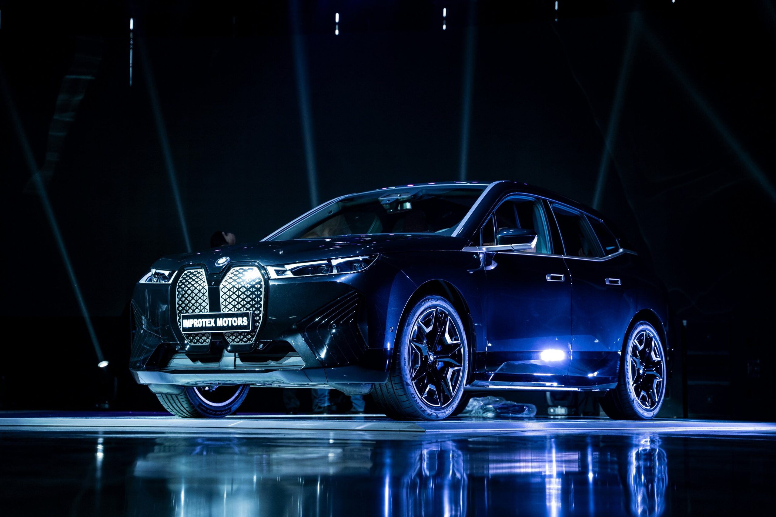 a blue car standing on a black background with lights