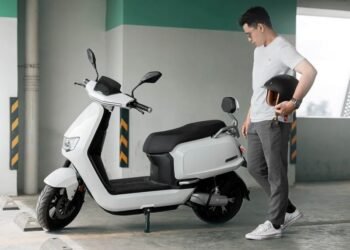 un homme regardant son scooter électrique