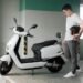 un homme regardant son scooter électrique